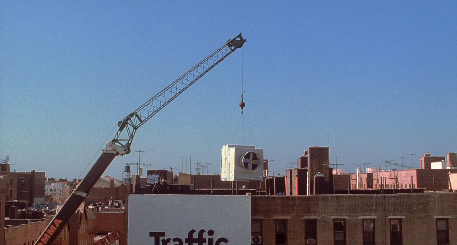 Crane suspended over New York rowhomes.