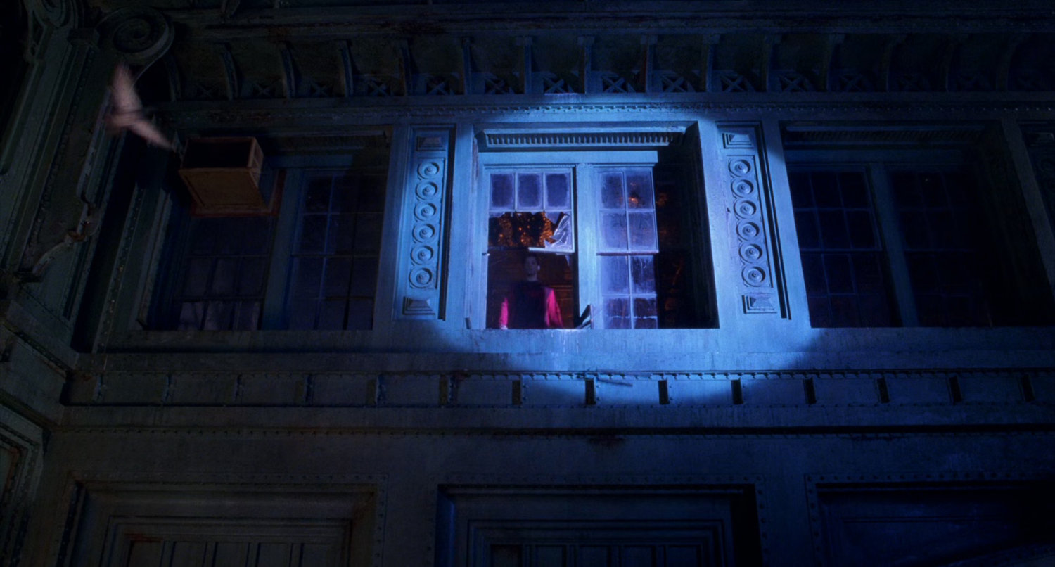 Spotlight on warehouse window at night.