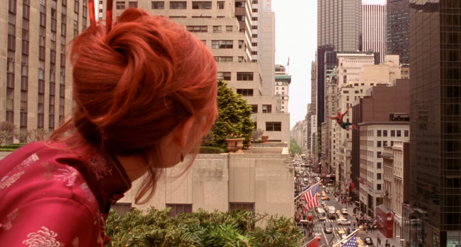 Mary Jane watching Spider-Man swing away over street.