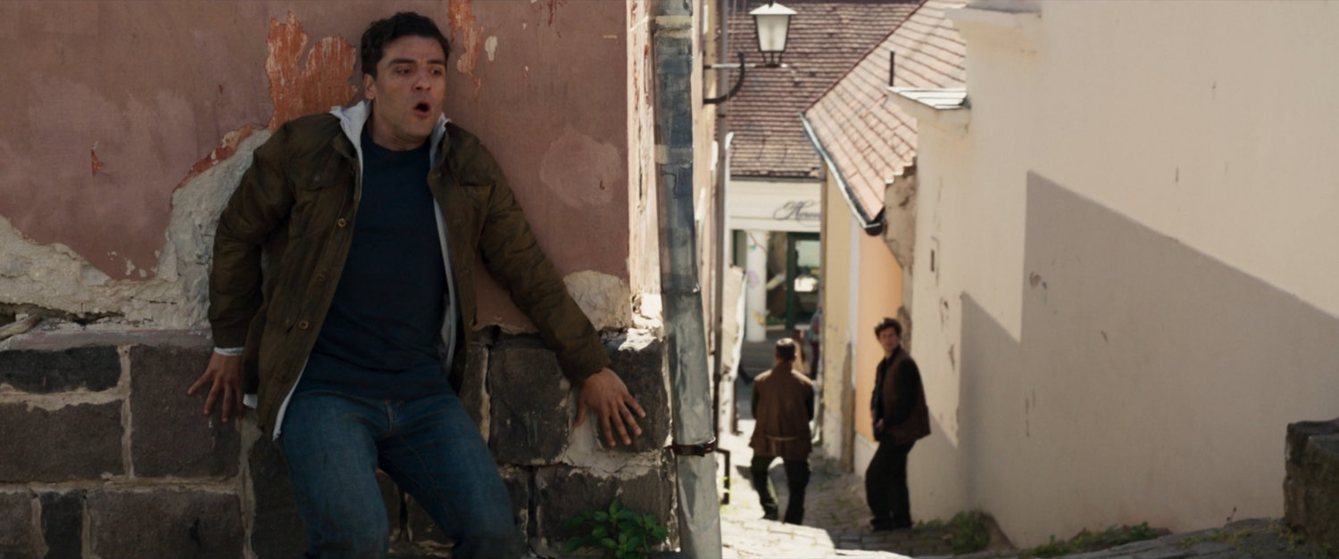 Steven hides behind a wall in a German village.
