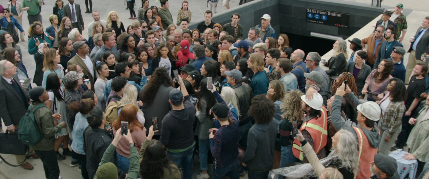Spider-Man and MJ are harassed by crowds at the entrance to the Penn Station subway.
