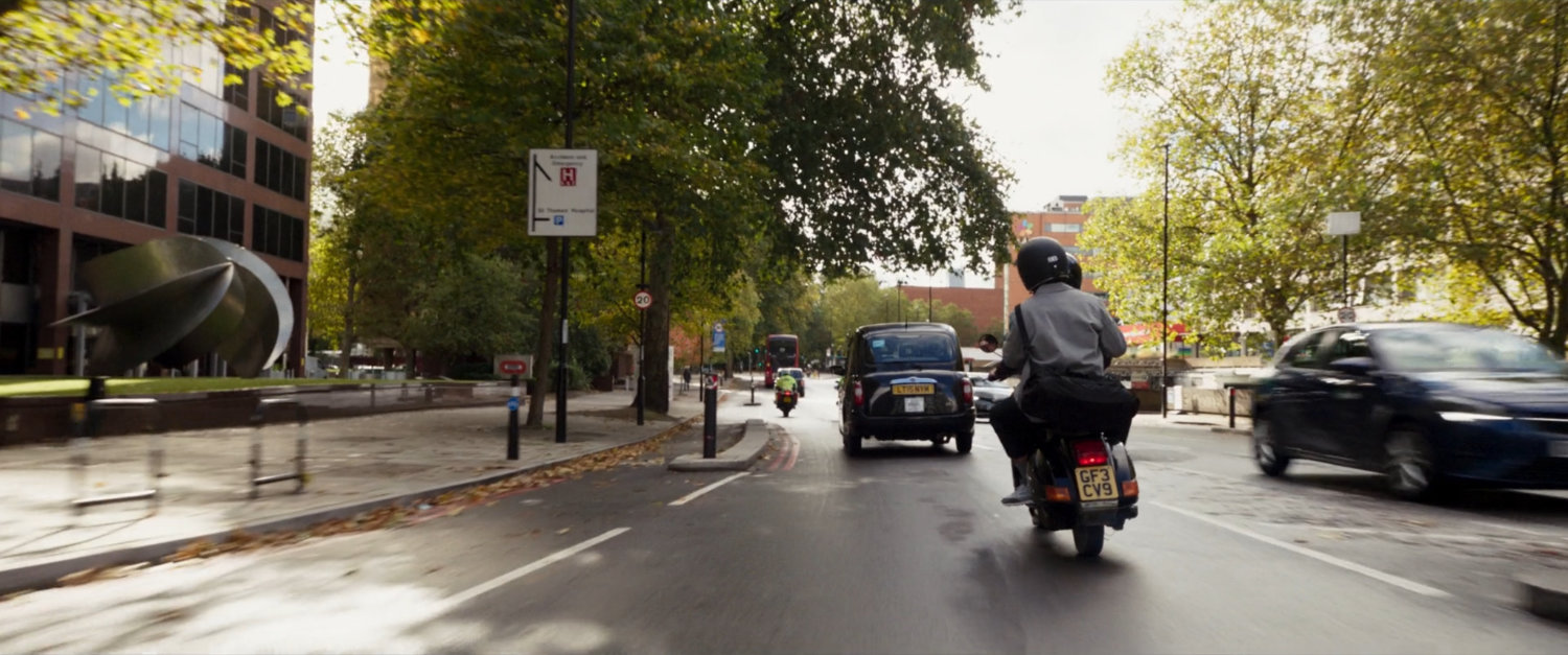 Layla and Steven on moped on London street.
