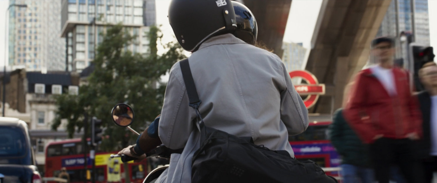 Layla and Steven on moped on London street.
