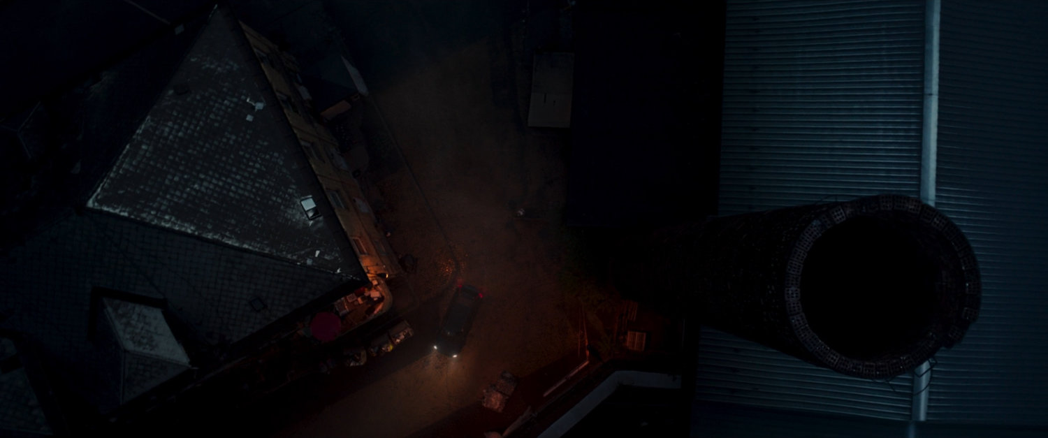 Aerial view of street next to factory tower.