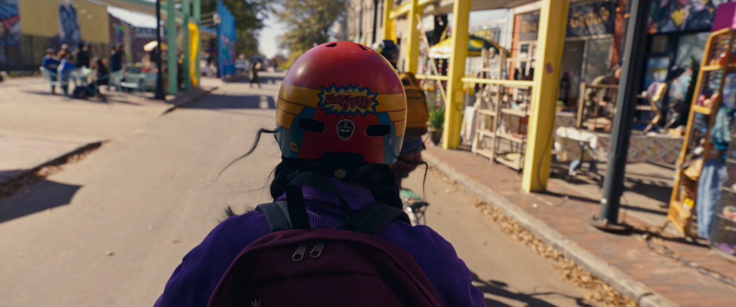 Kamala on bike riding down street.