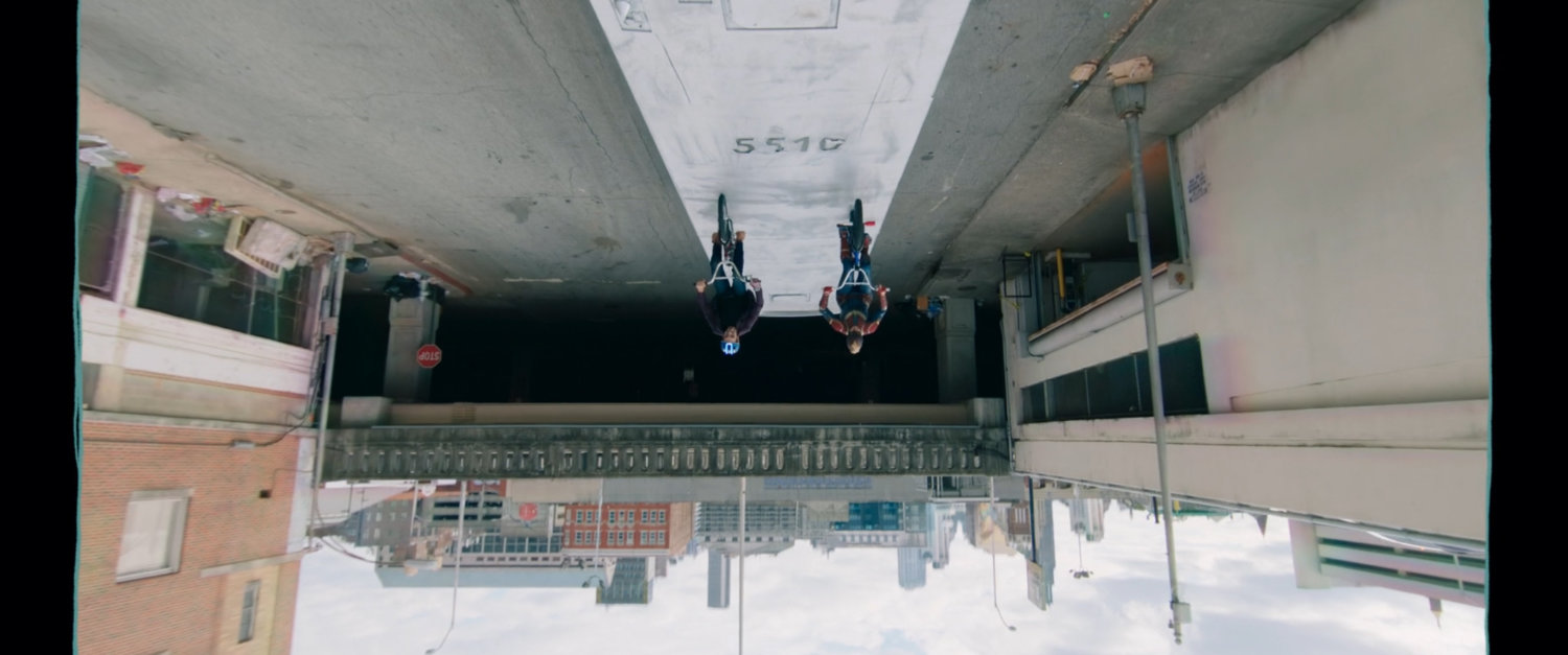 Upside down image of Kamal and Bruno riding bikes on top of bus.