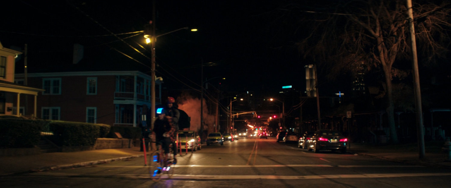 Kamala bikes through Jersey City neighborhood at night.