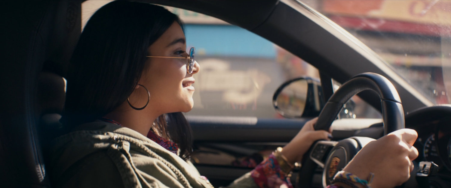 Kamala in car in shopping district.