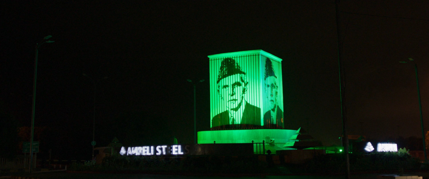 Nighttime view of Karachi roundabout with monument.