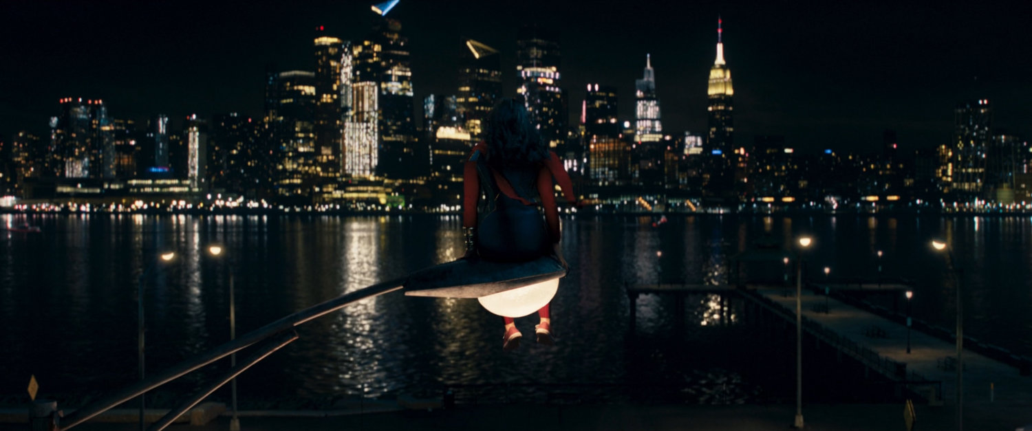 Kamala sitting on street light with New York in the background.
