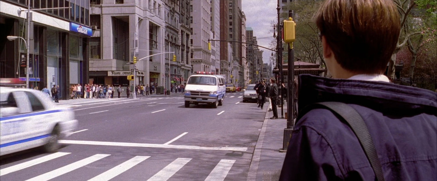 Peter Parker watching police cars drive by.