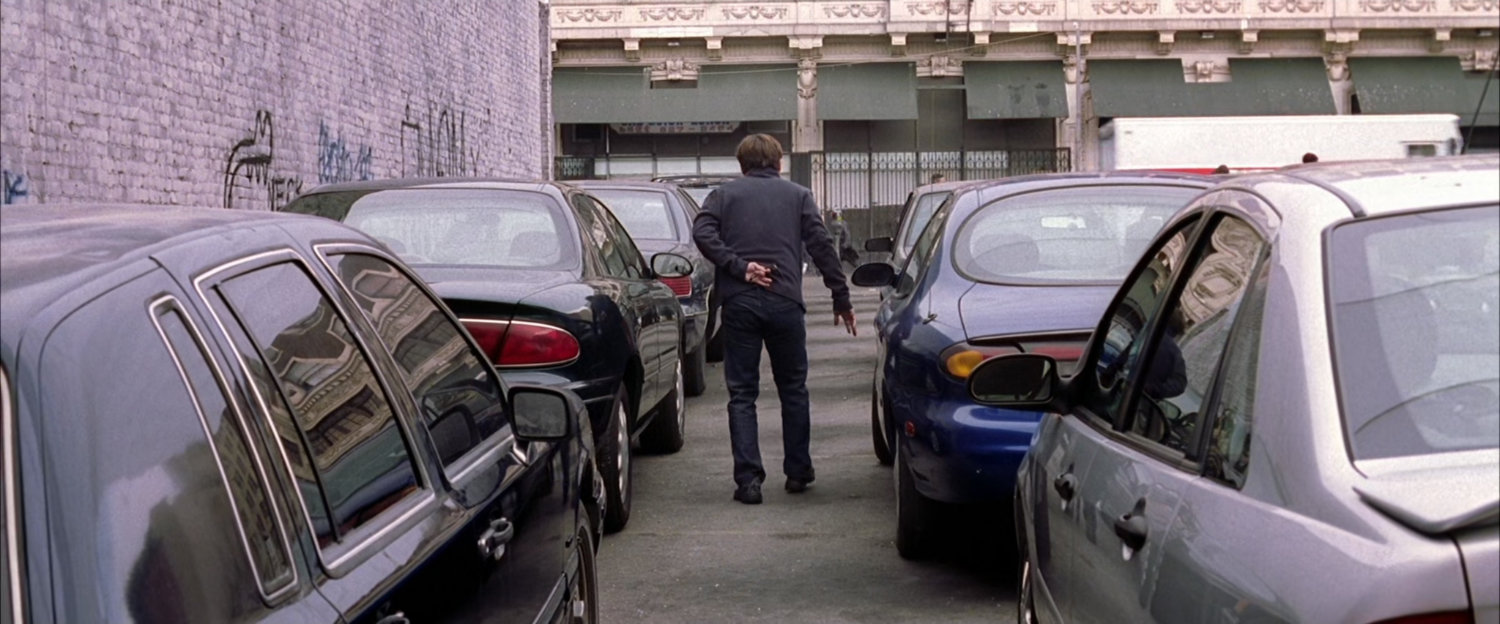 Peter Parker walking through parking lot.