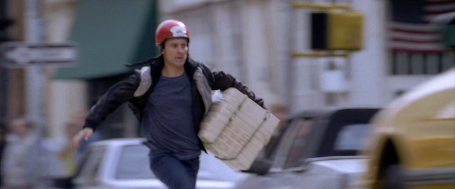 Peter runs across street with pizza boxes.