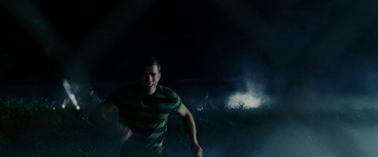 Exterior Marshlands with Flint Marko running from flashlights.