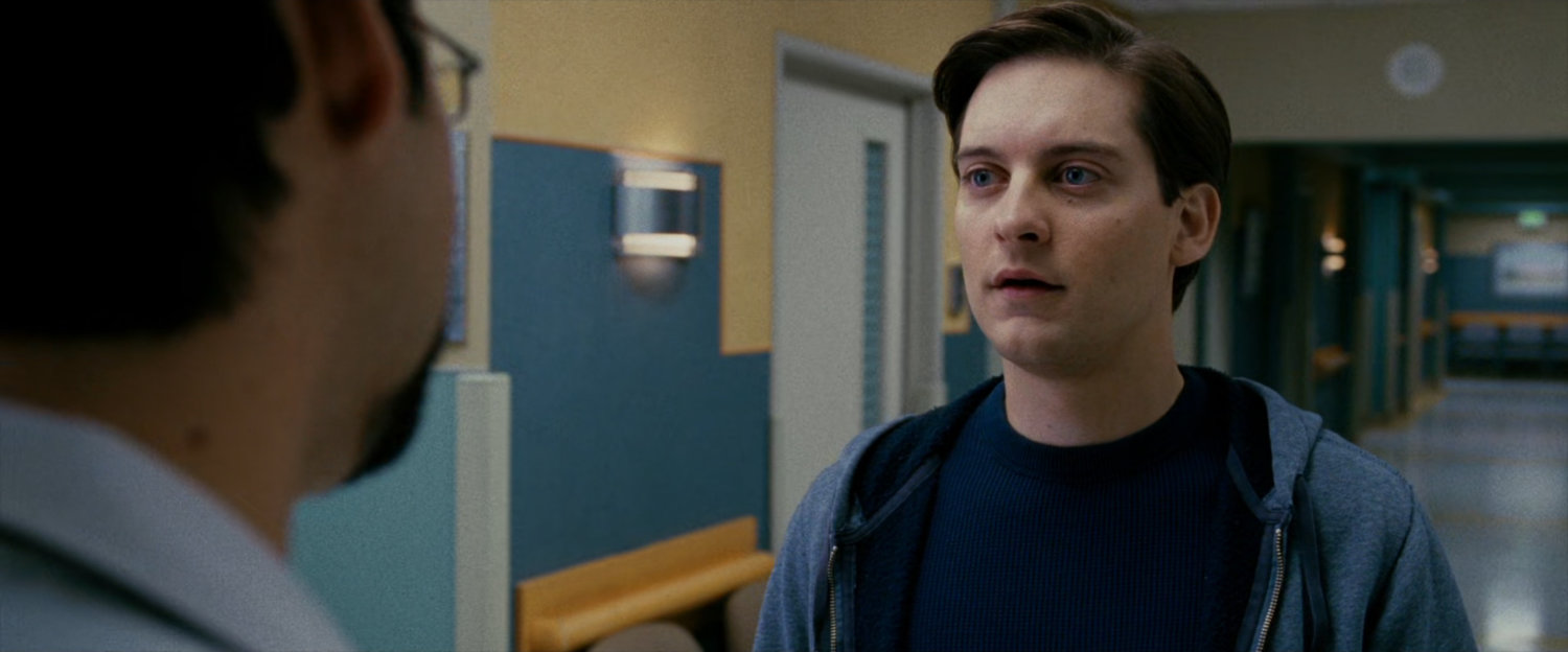 Peter Parker speaks to a doctor in hospital hallway.