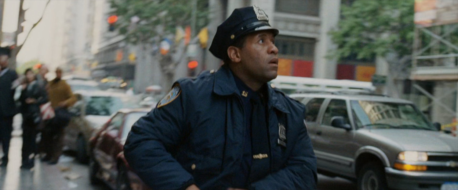 Police officer looking up as cars pass by.