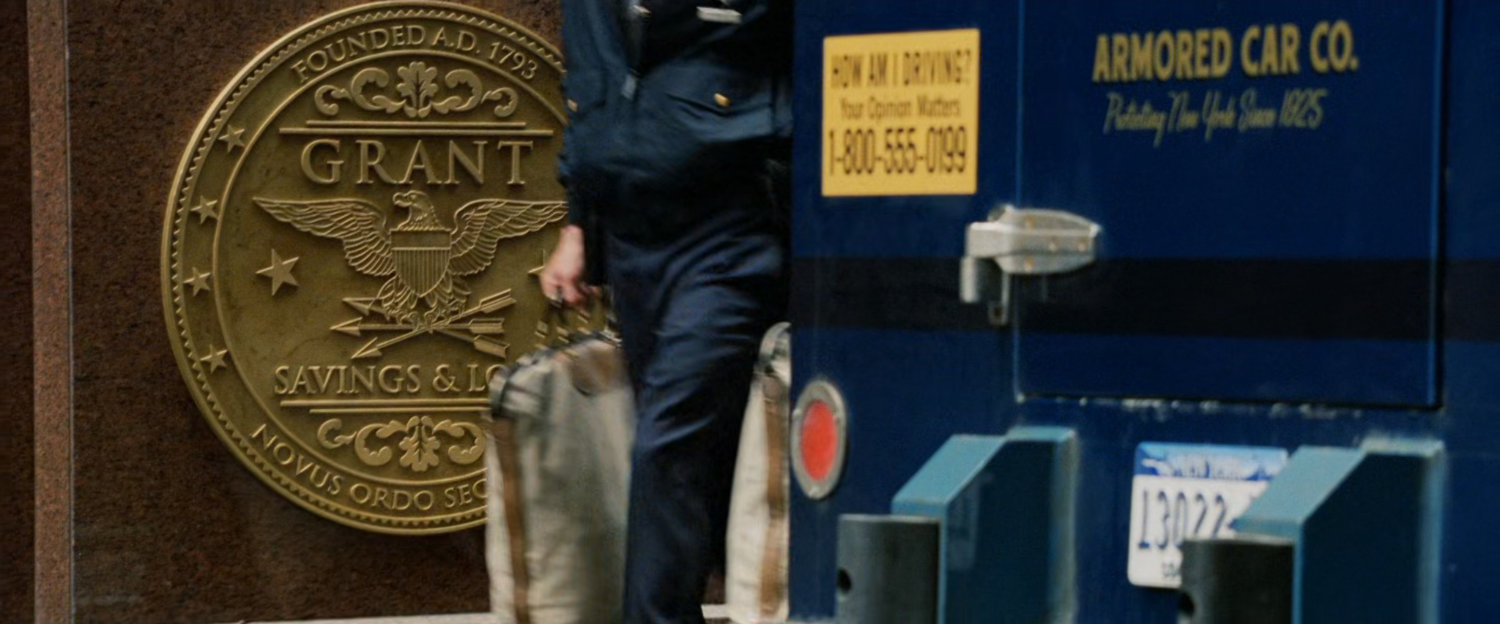 Bank officer loads cash into armored car at Grant Savings and Loan.