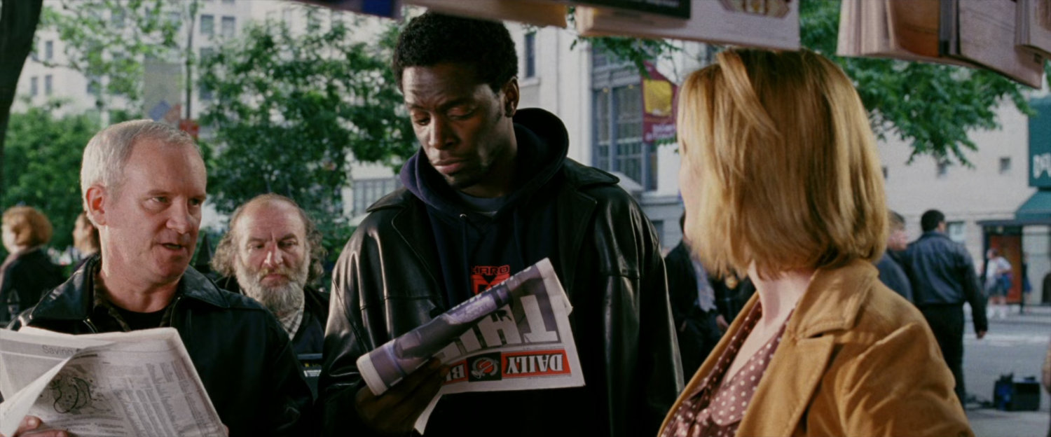 People looking at newspapers at corner newsstand.