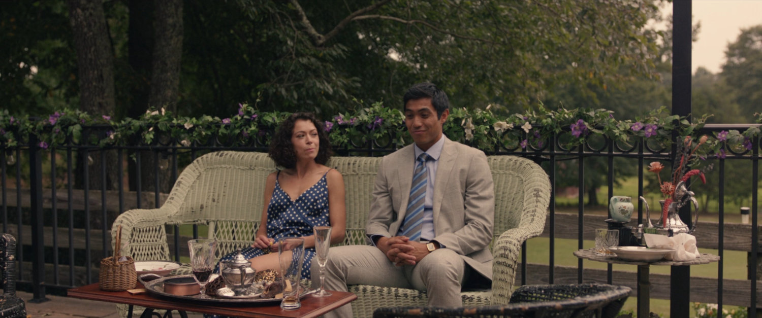 Jena and Josh sit on a bench at the Wedding Venue.