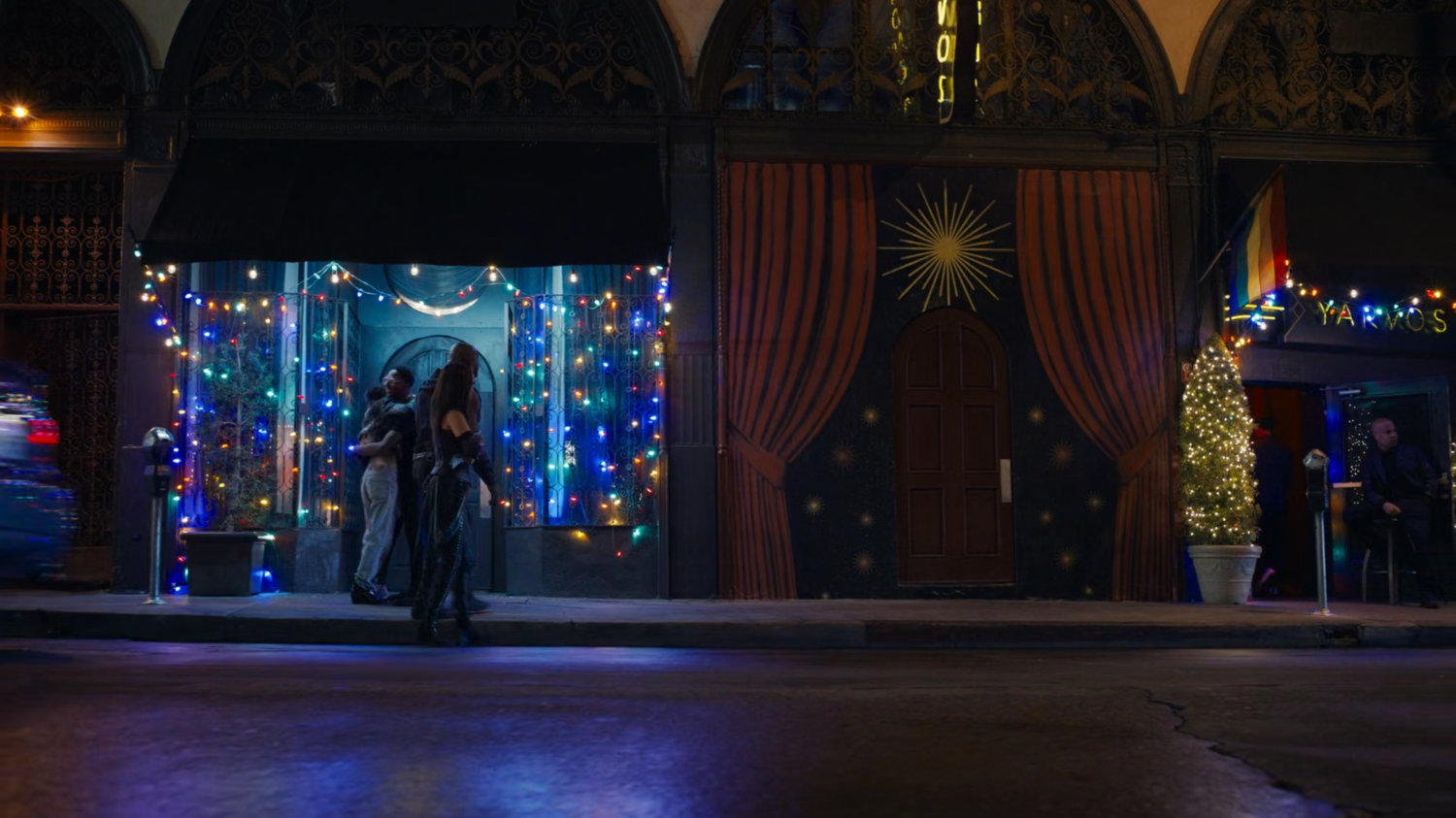 Mantis and Drax walk along a sidewalk at night.