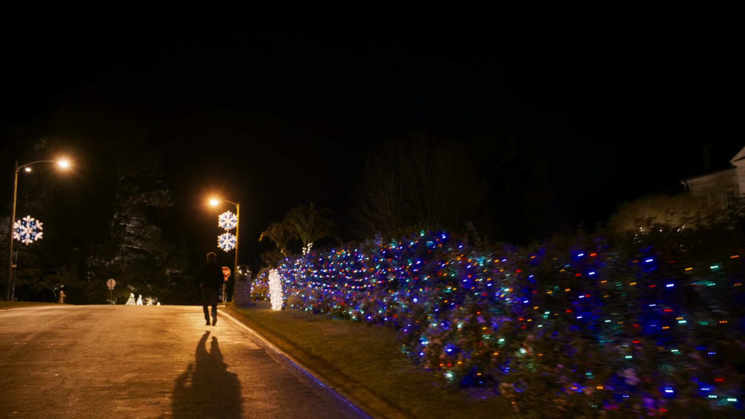 Kevin Bacon running down a street in a Beverly Hills neighborhood at night.