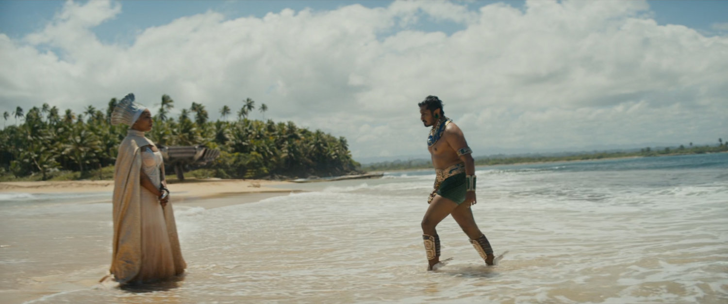 Namor walks out of the ocean towards Romanda.