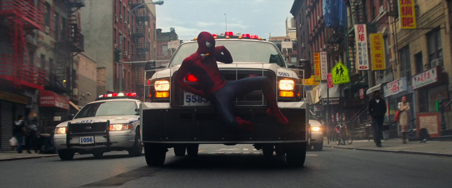 Spider-Man catches a ride on the front of an emergency vehicle.