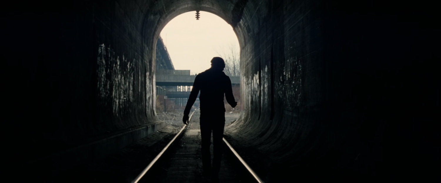 Silhouetted Peter Parker exits tunnel.