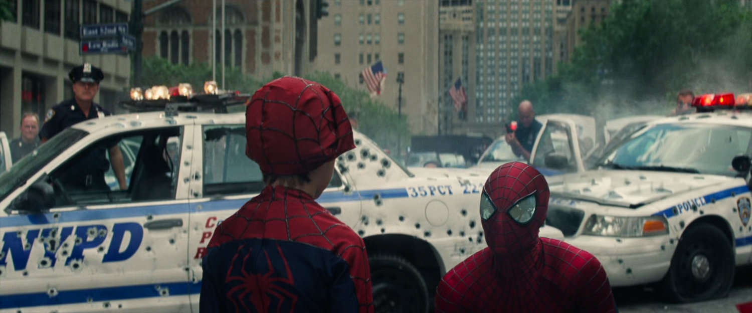 Spider-Man talks to a small bot in a Spidey costume.