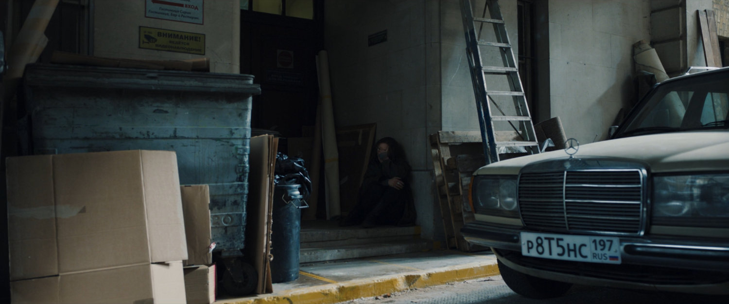 G'iah huddled in an alcove of an alley.