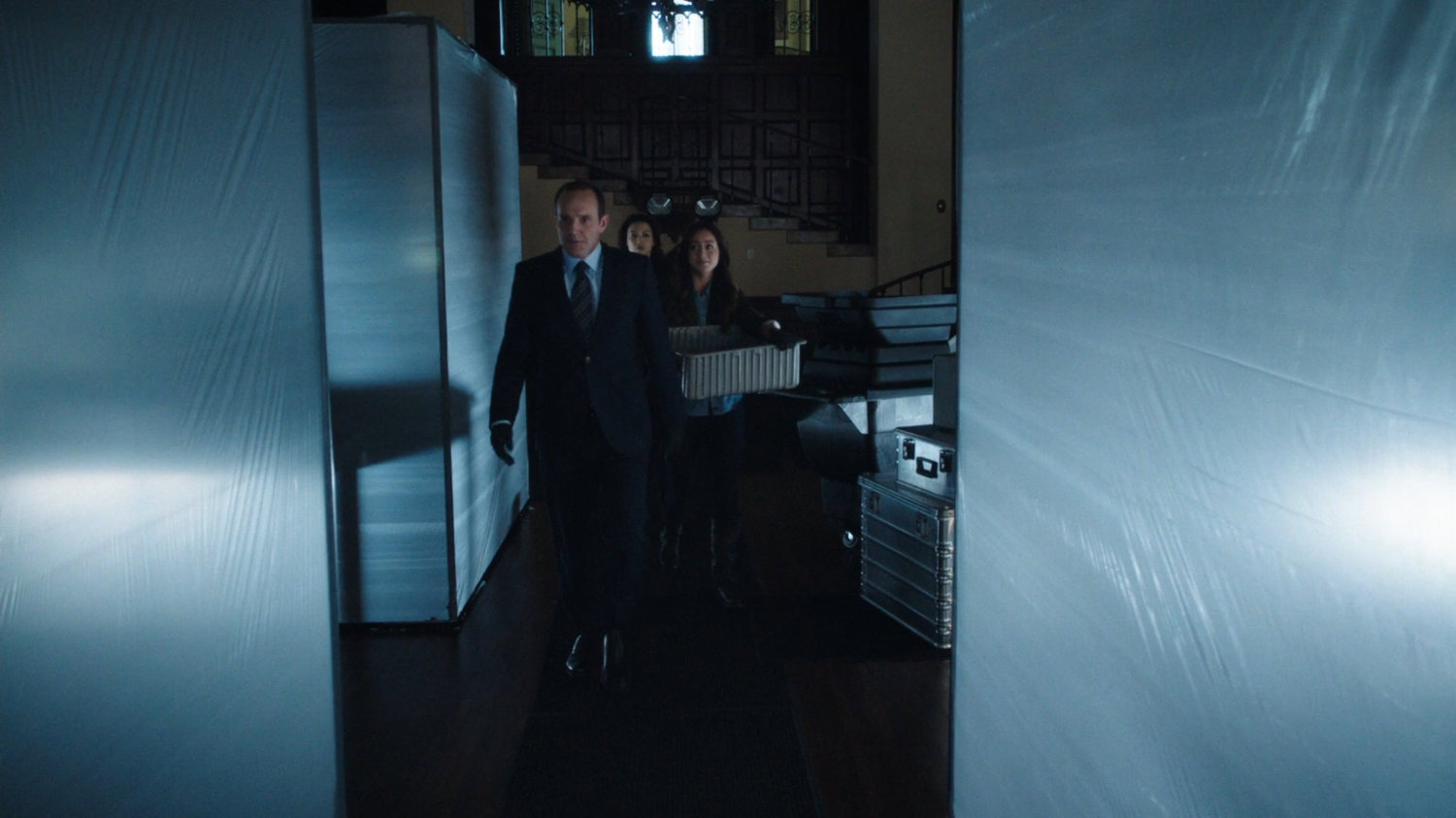 Coulson and team walk between plastic tenting in a Greenwich University office.