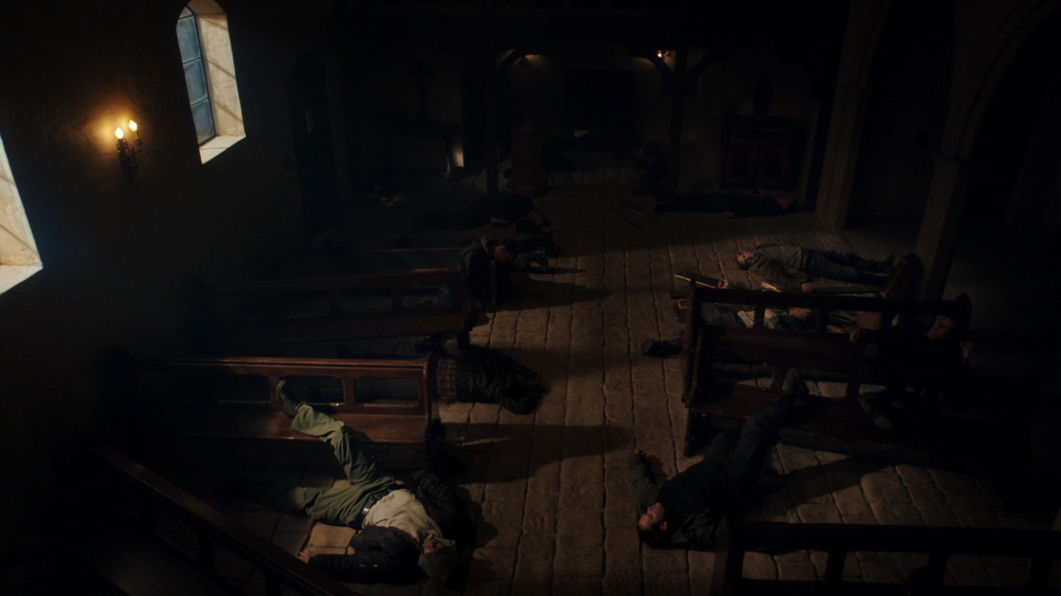 Bodies strewn on floor in dark interior of Irish Monastery.