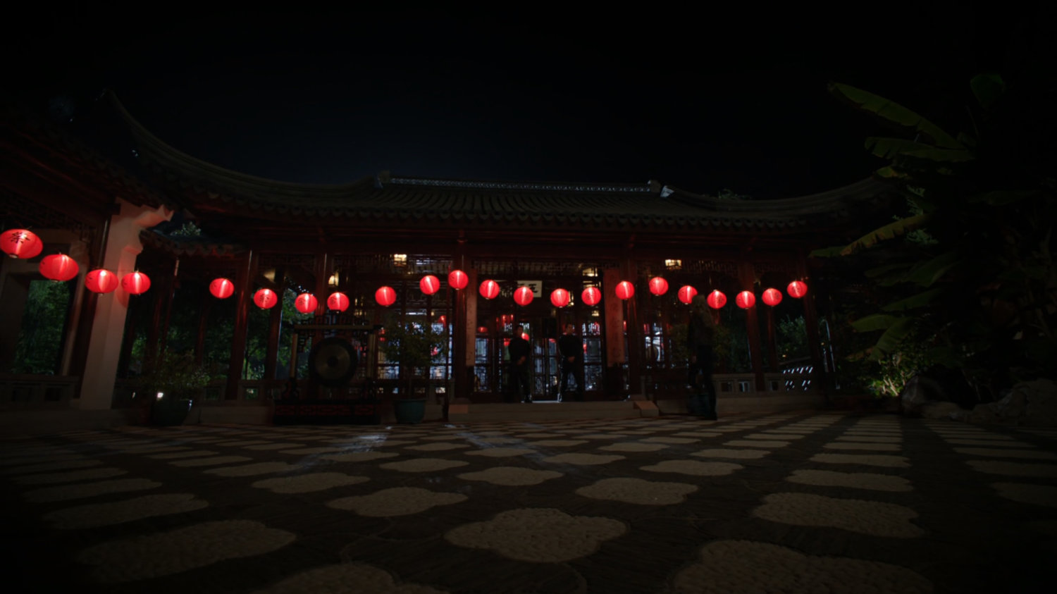 A Japanese pagoda at night lit by red lanterns.