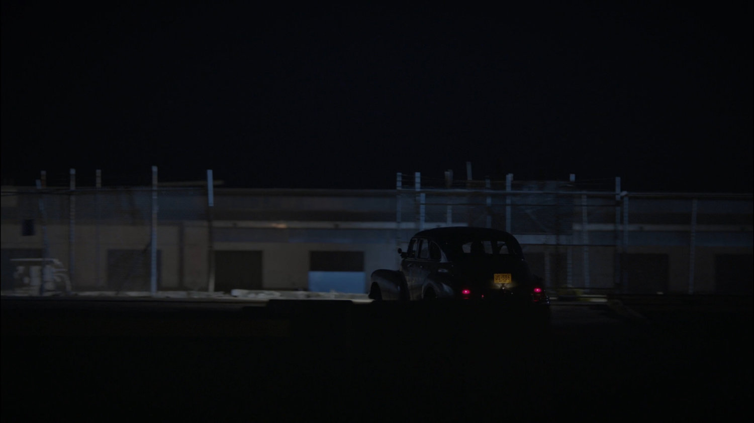 Car drives into warehouse area.