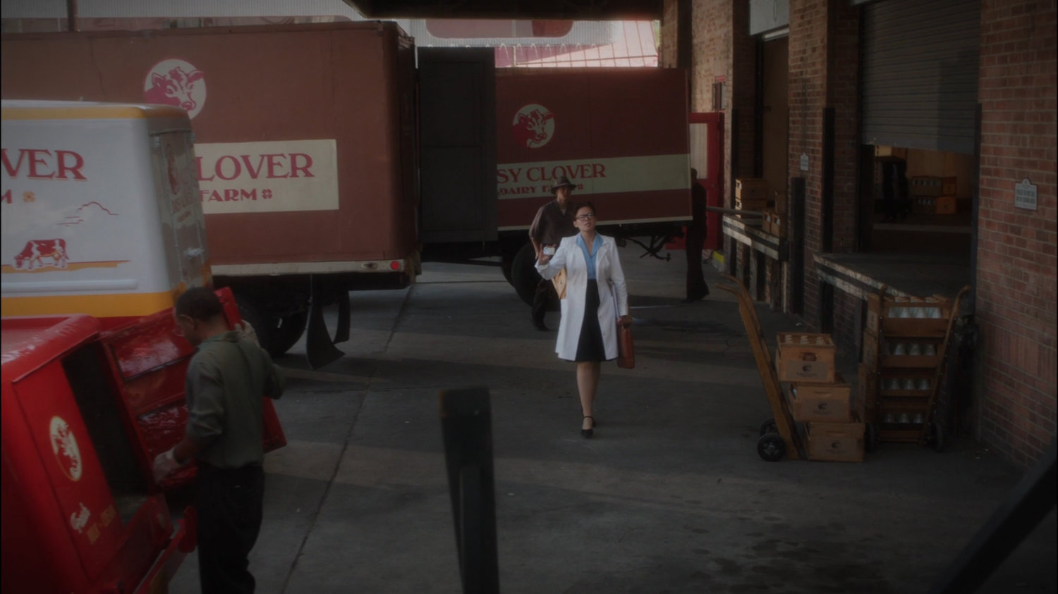 Peggy walks past milk trucks at Daisy Clover Dairy.