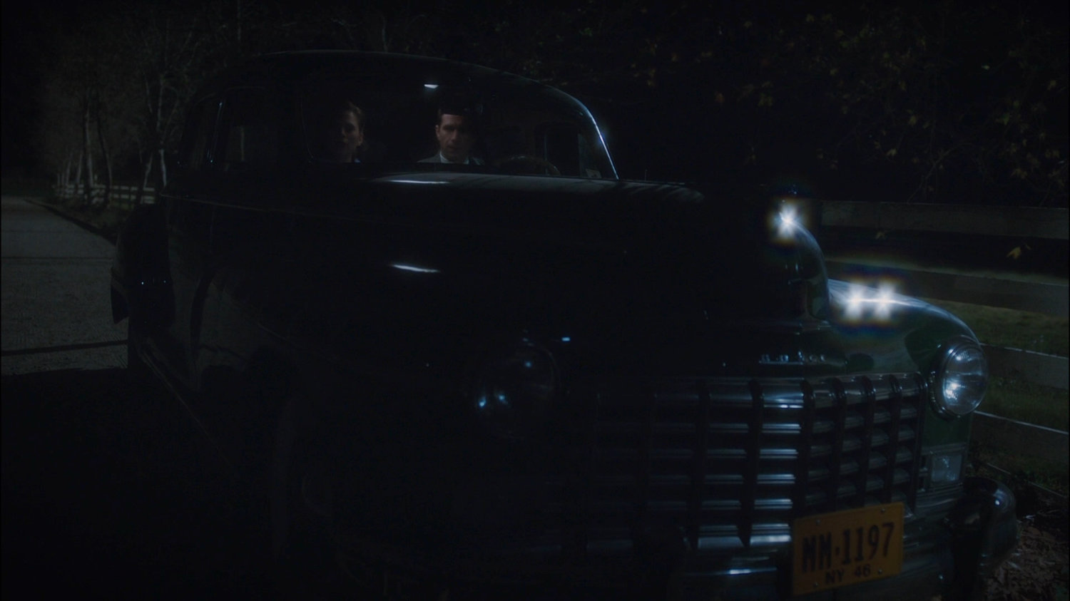 Peggy and Jarvis parked in car outside Sheldon McFee's house.