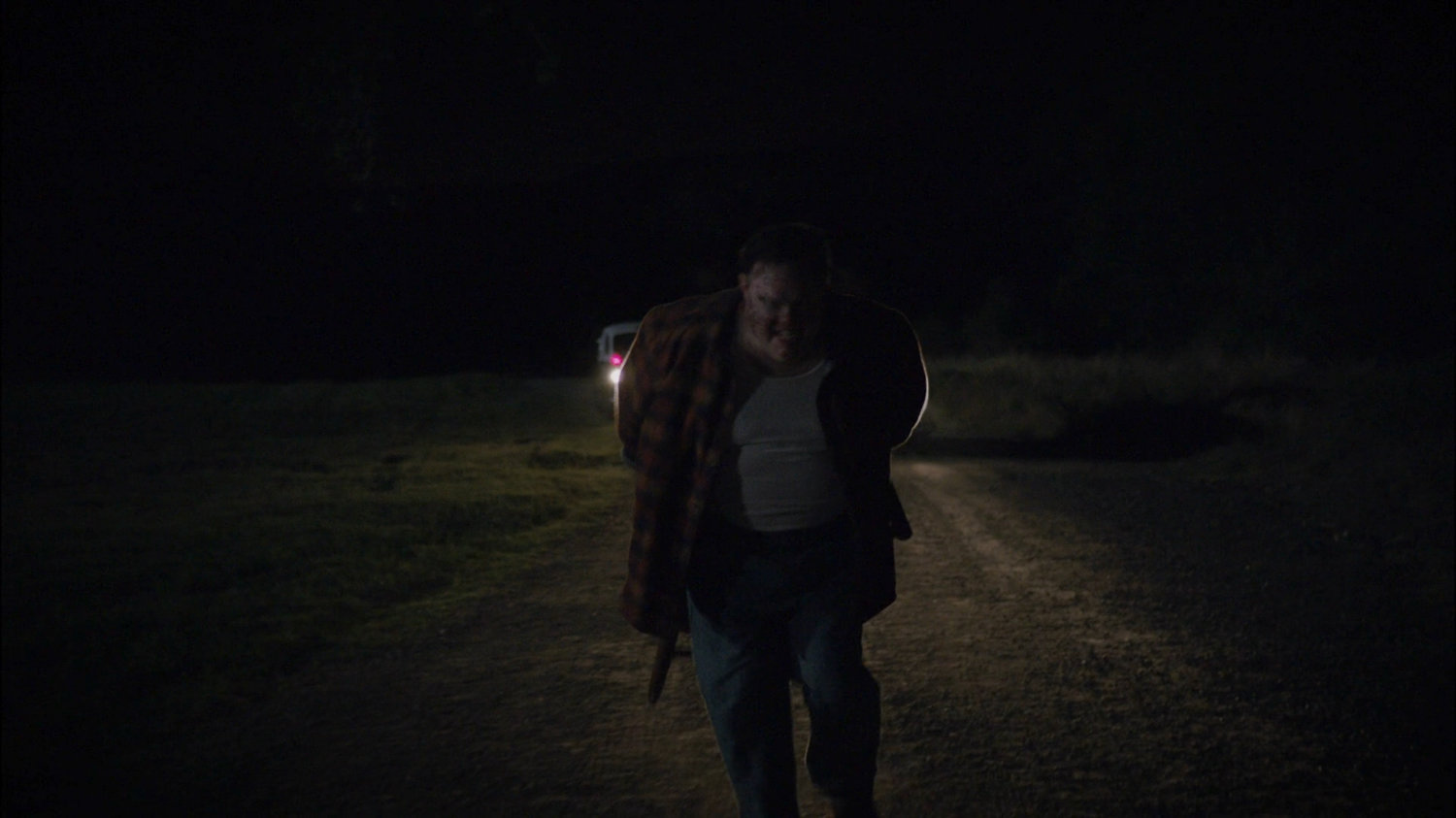 Sheldon McFee running on dirt road with chair strapped to back.
