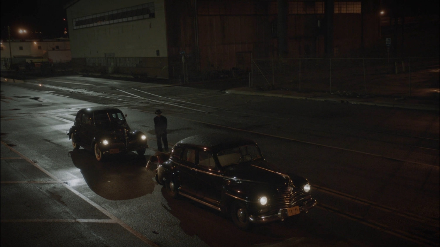 Two cars on a wet New York street.
