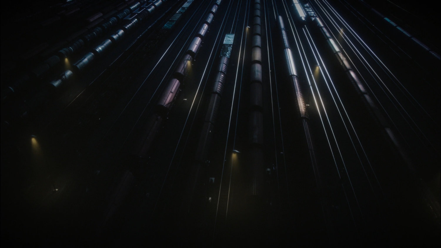 Nighttime high angle view of trains in railyards.
