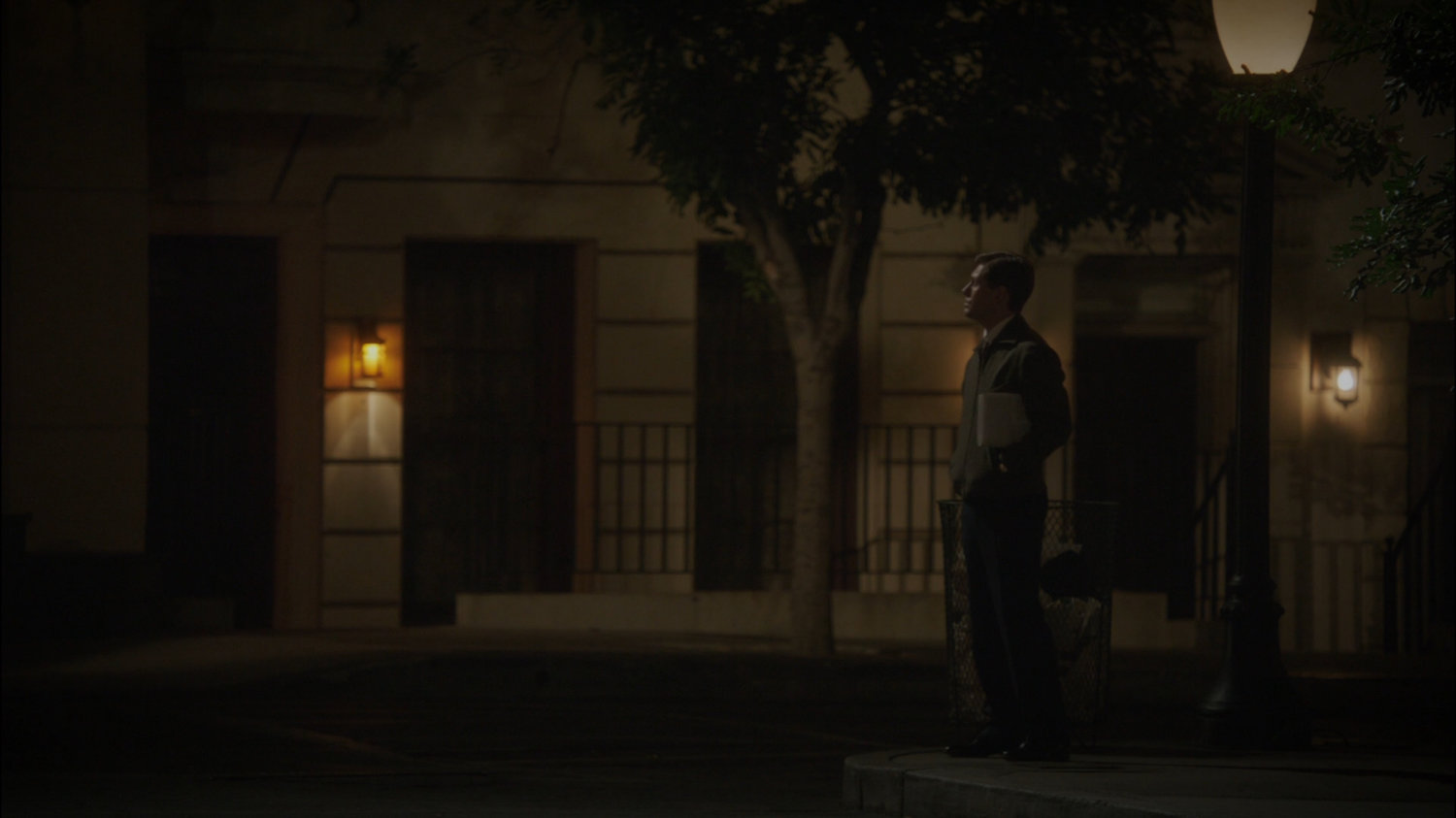 Man standing in front of dark New York city building.