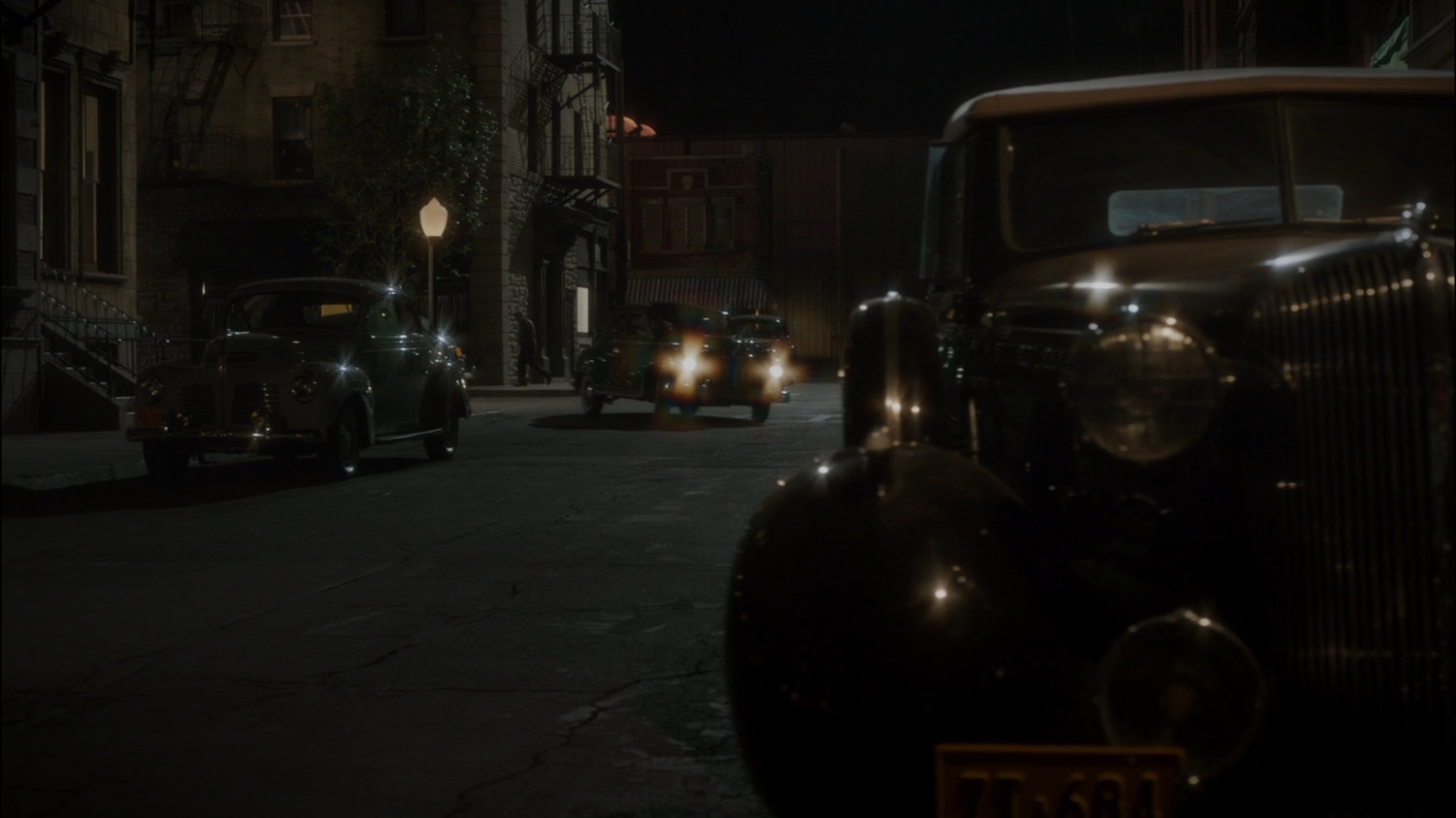 Car turns corner on dark New York city street across from The Griffith Hotel.