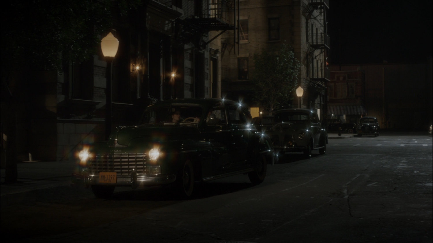 Car parks on dark New York city street across from The Griffith Hotel.