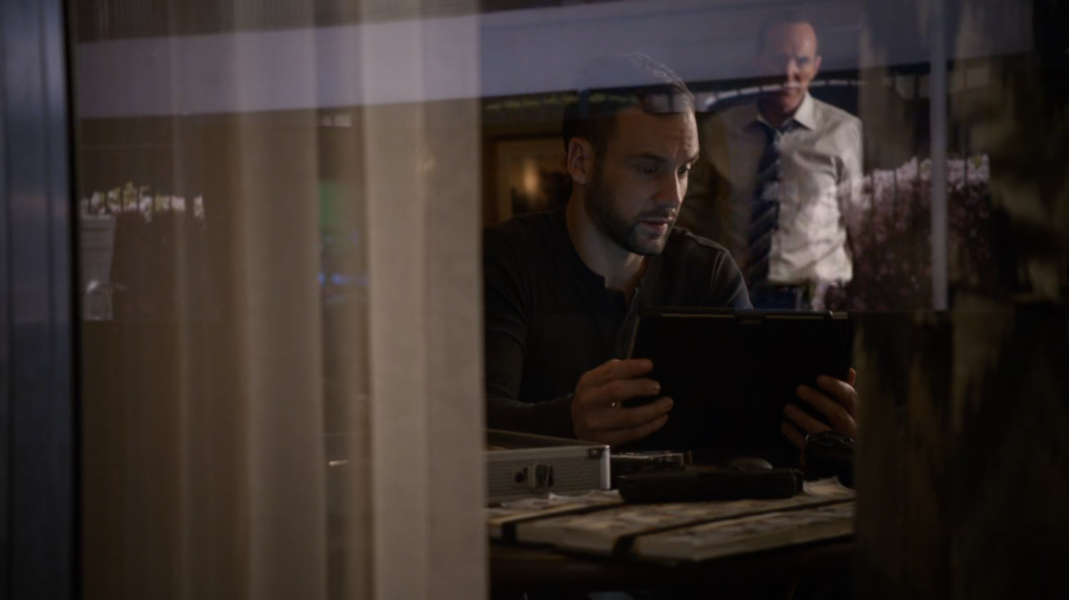 Looking at Coulson and Hunter inside motel room from outside.