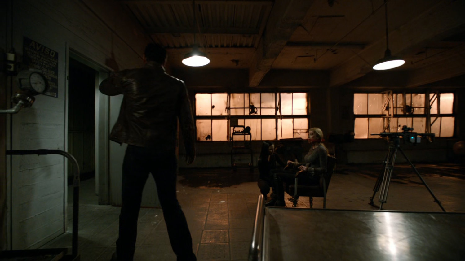 Ward ties Bobbi to chair as bait in a trap inside an abandoned Spanish warehouse.