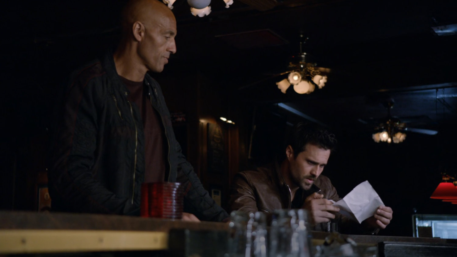 A bald man approaches Ward in a bar.