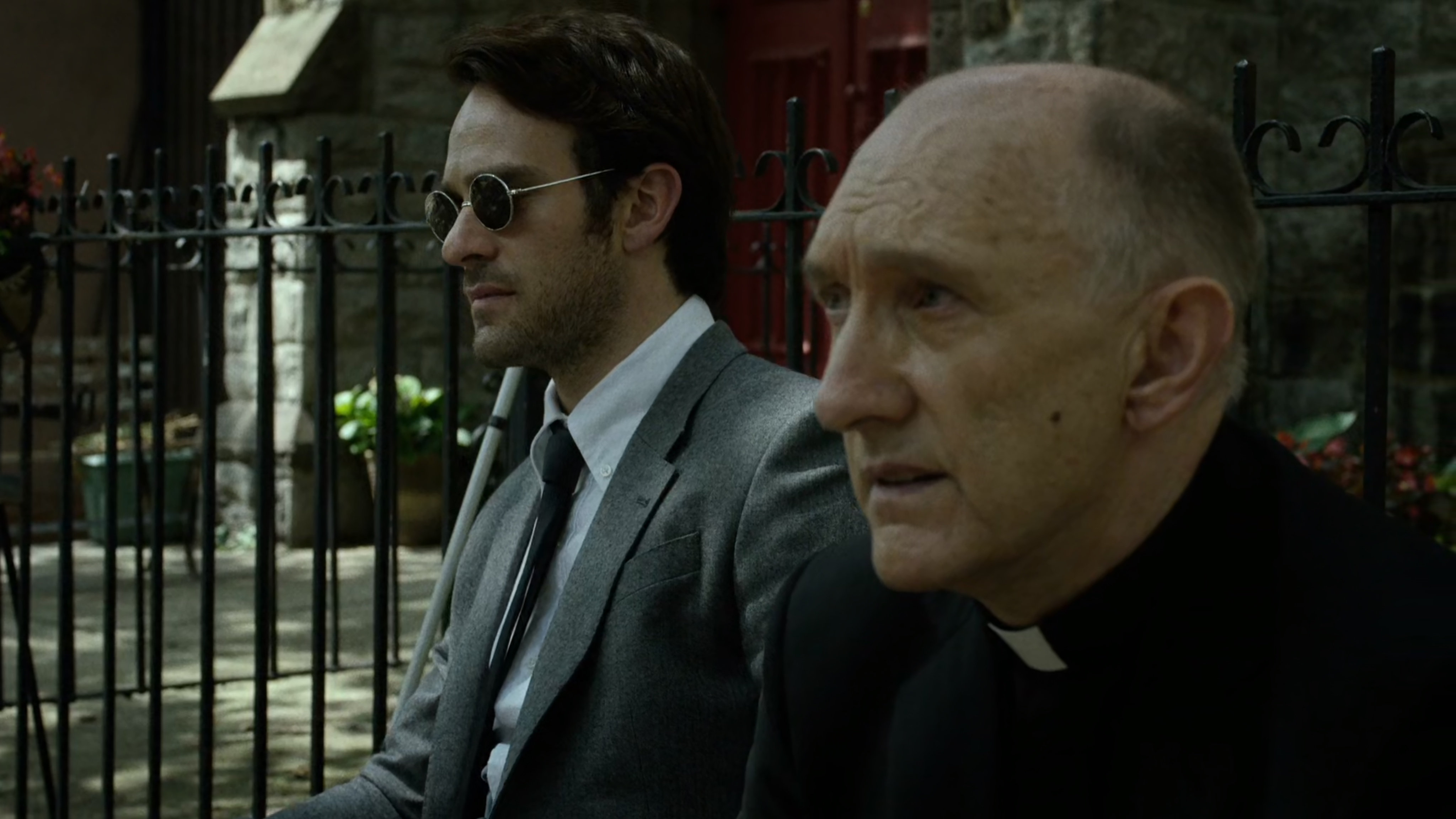 Father Lantom and Matt sit outside church.