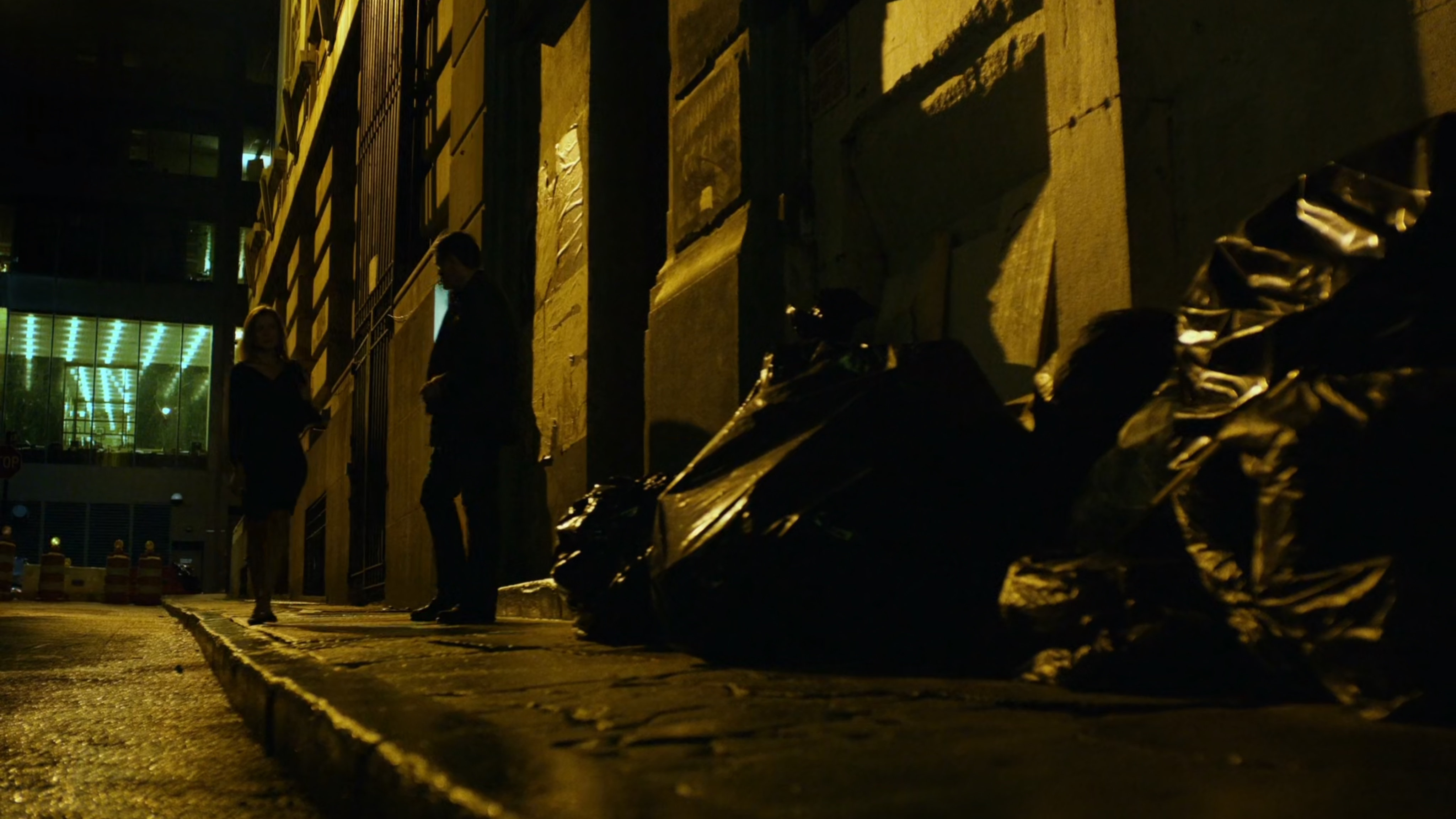 Man confronts female juror on sidewalk at night.