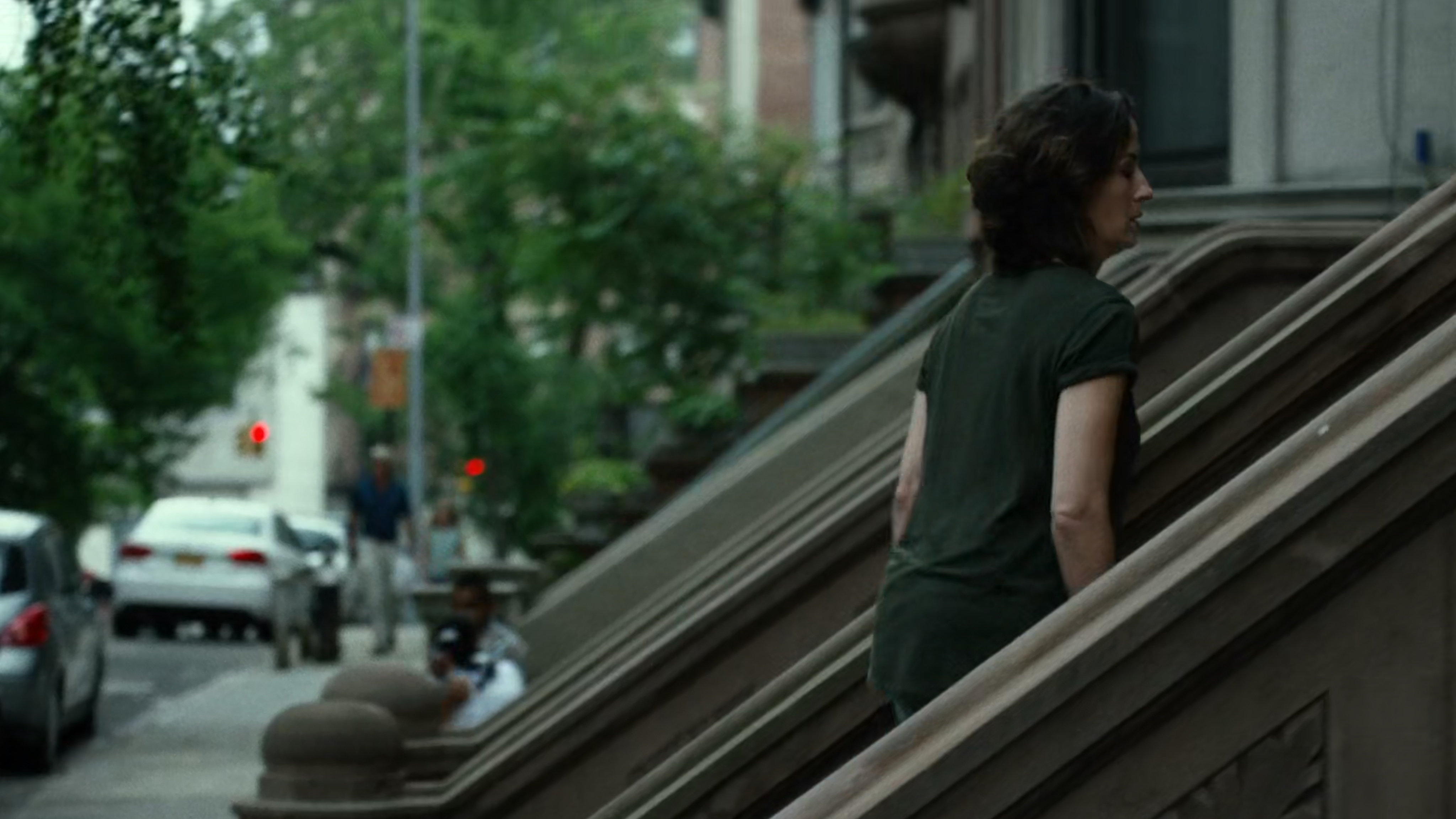 Mrs Fisher on steps of brownstone.