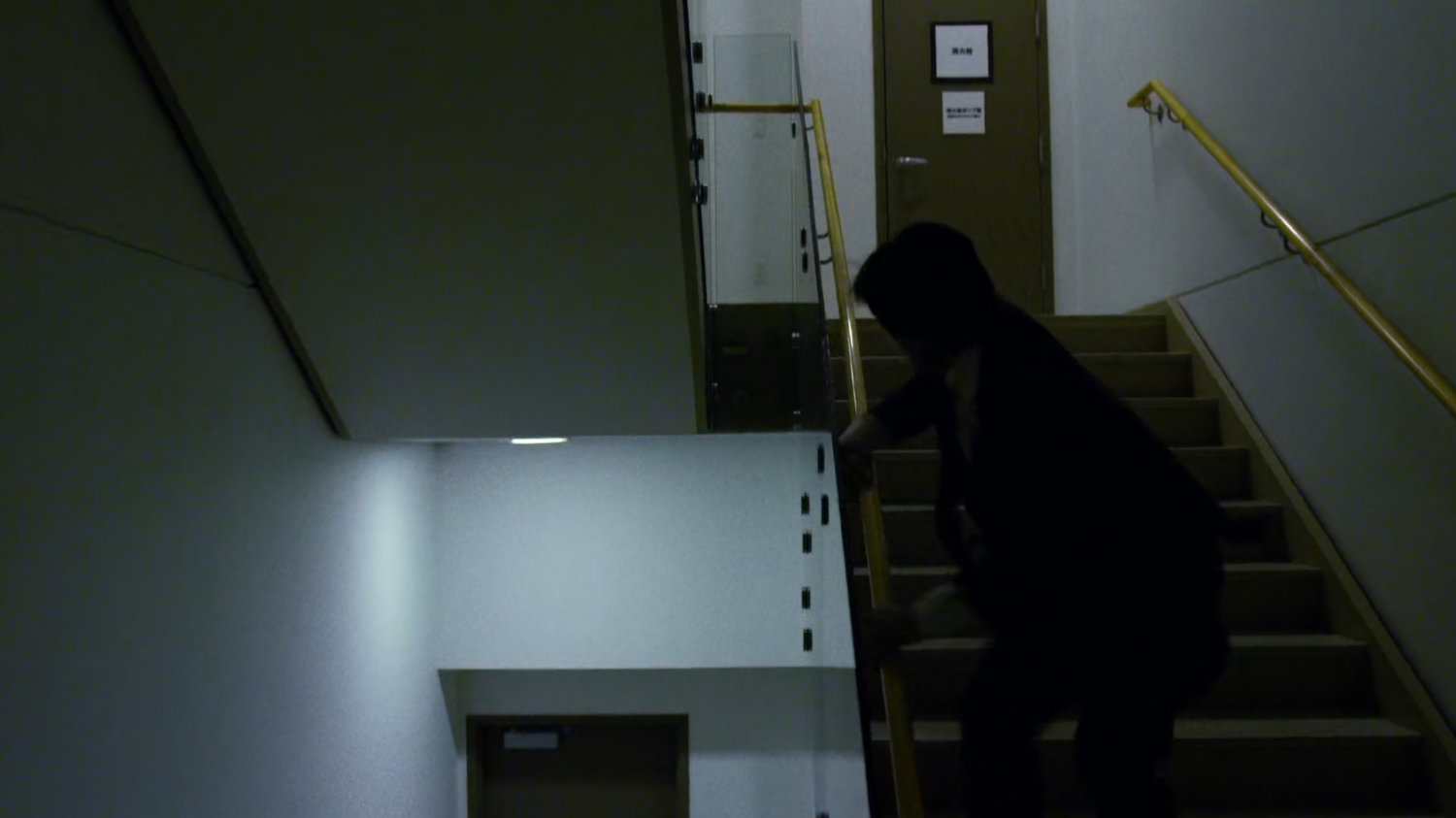 Aito runs down stairwell in Tokyo office building.