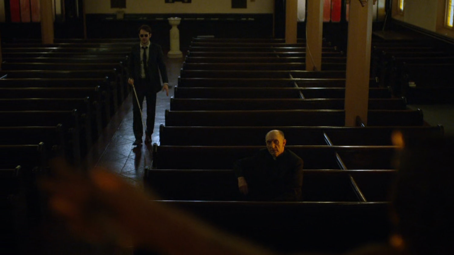 Matt and Father Lantom in church pews.